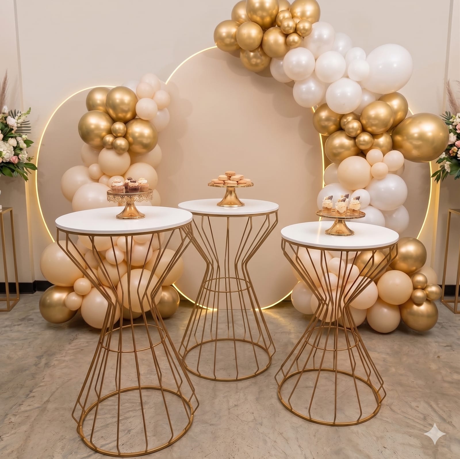 Mesas doradas para decorar con arco de globos y estación de postres para eventos
